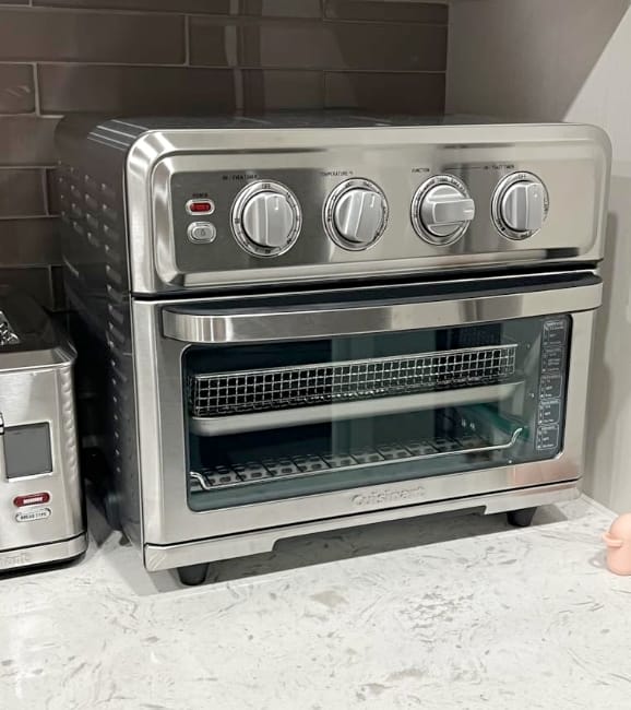 Image of Cuisinart non-toxic air fryer oven sitting on white marble countertop next to toaster