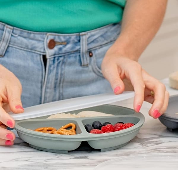 WeeSprout-Silicone-Dish on table with food in it and a woman grabbing the sides of the plate to lift it up