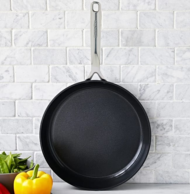 Image of Greenpan GP5 Black ceramic nonstick pan with no teflon hanging on gray tile wall