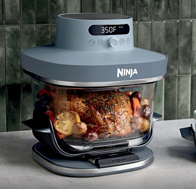 Image showing Ninja Crispi Pro non toxic air fryer with whole chicken cooking inside of it on countertop